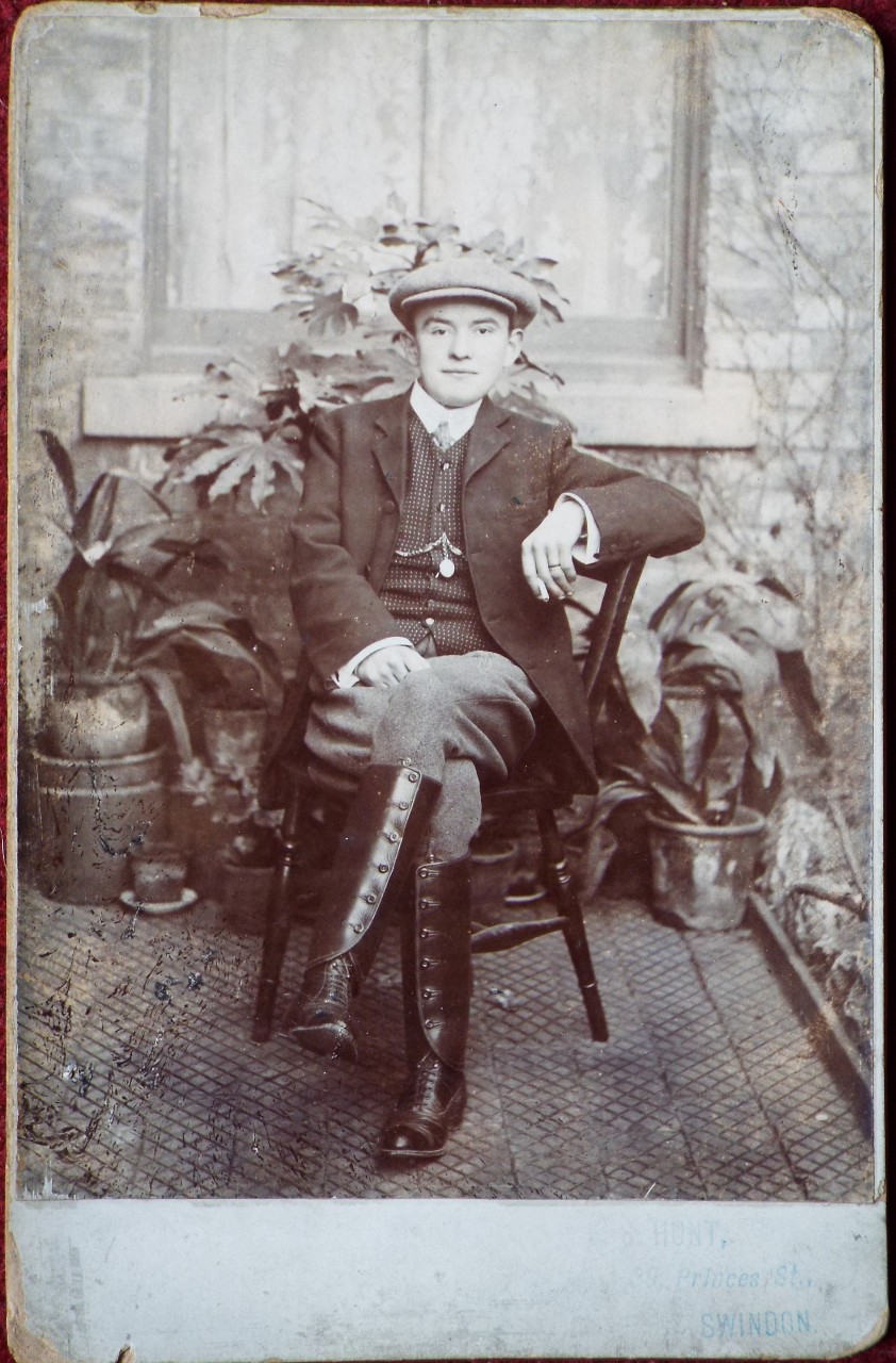 Photograph - Seated man outside his house, with pot plants